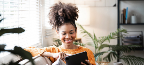 A woman seated and holding a tablet, symbolizing Zown's budget-boosting pre-approval offer