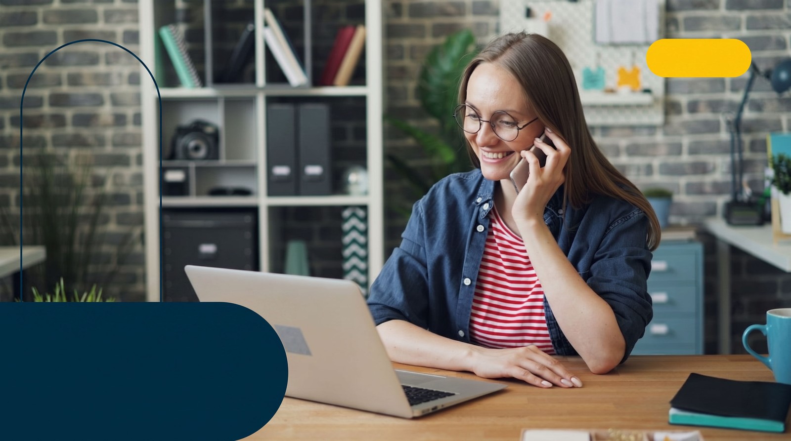 A woman on the phone with a mortgage lender while working at her laptop, illustrating the first call in getting pre-qualified or pre-approved.