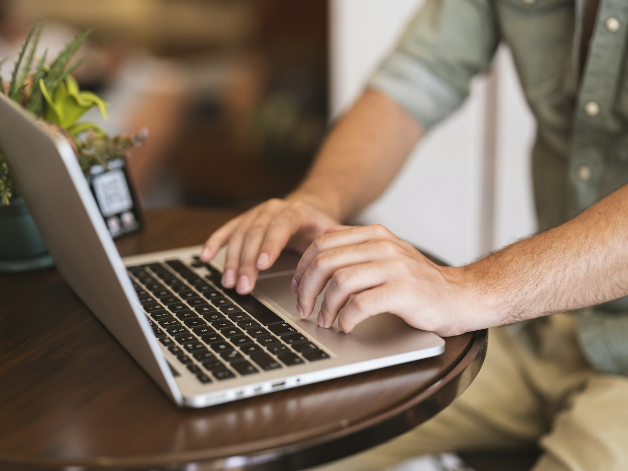 Close-up of hands typing on a laptop while researching a home purchase