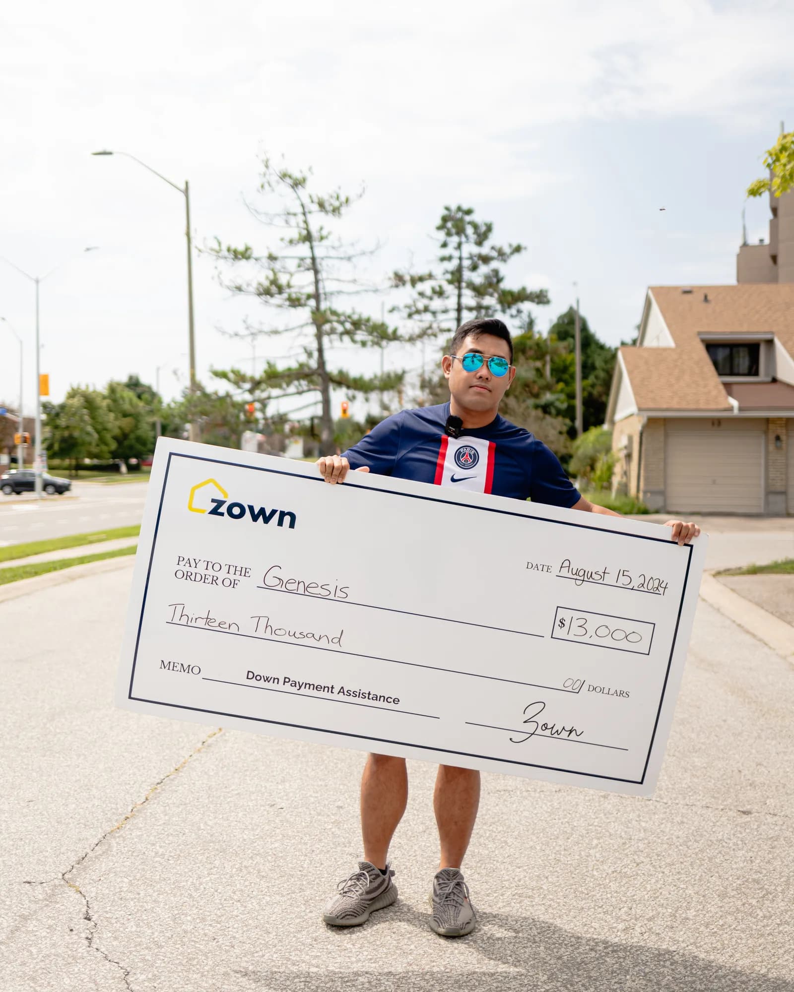 Genesis holding their Zown boost cheque