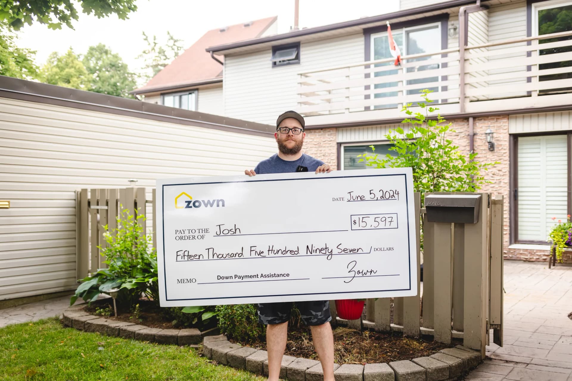 Josh holding their Zown boost cheque