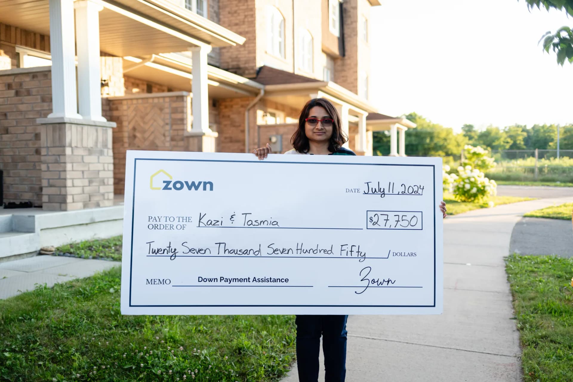 Tasmia holding their Zown boost cheque
