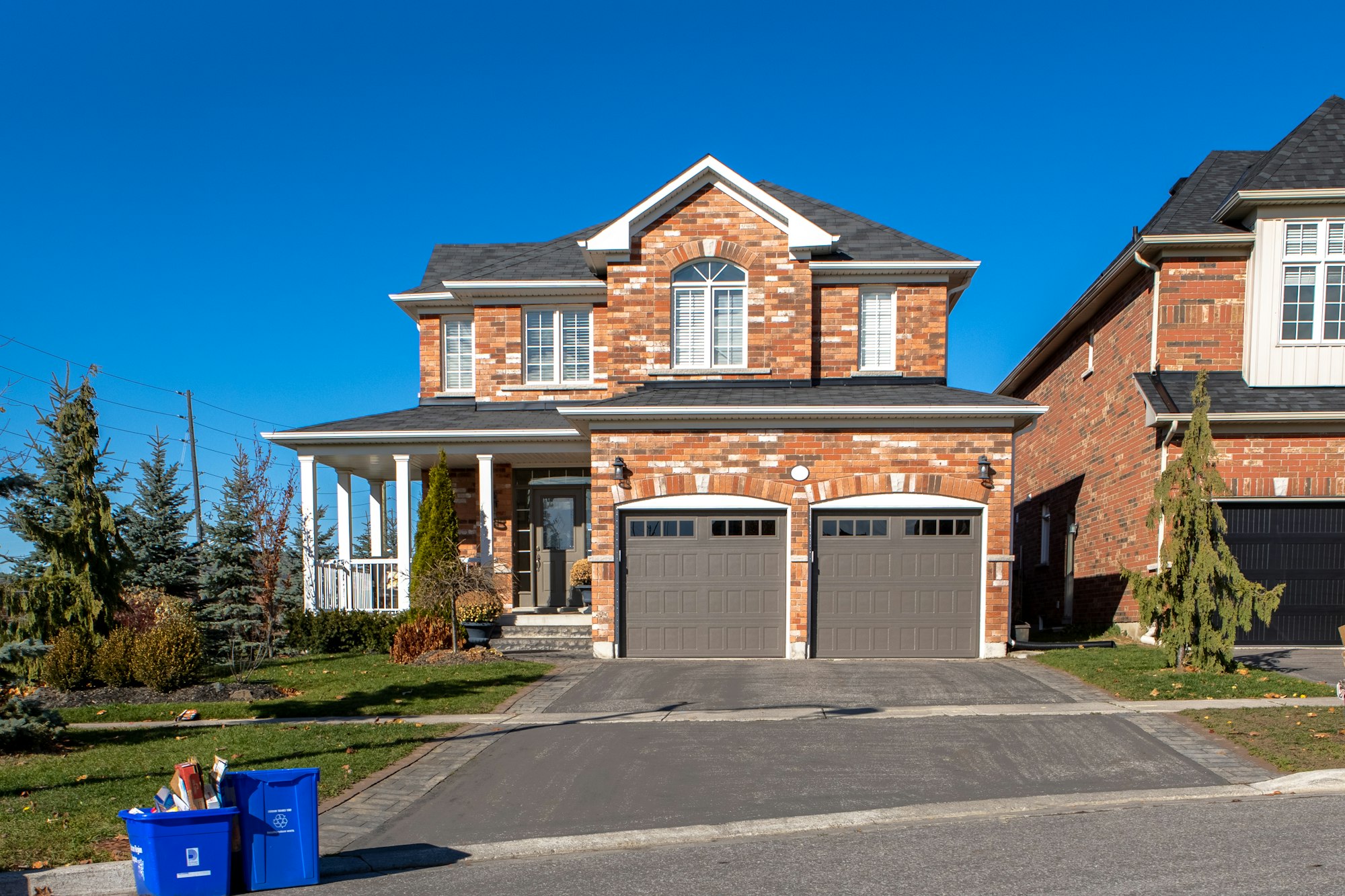 Brick two-storey detached home with double garage on an Ontario suburban street