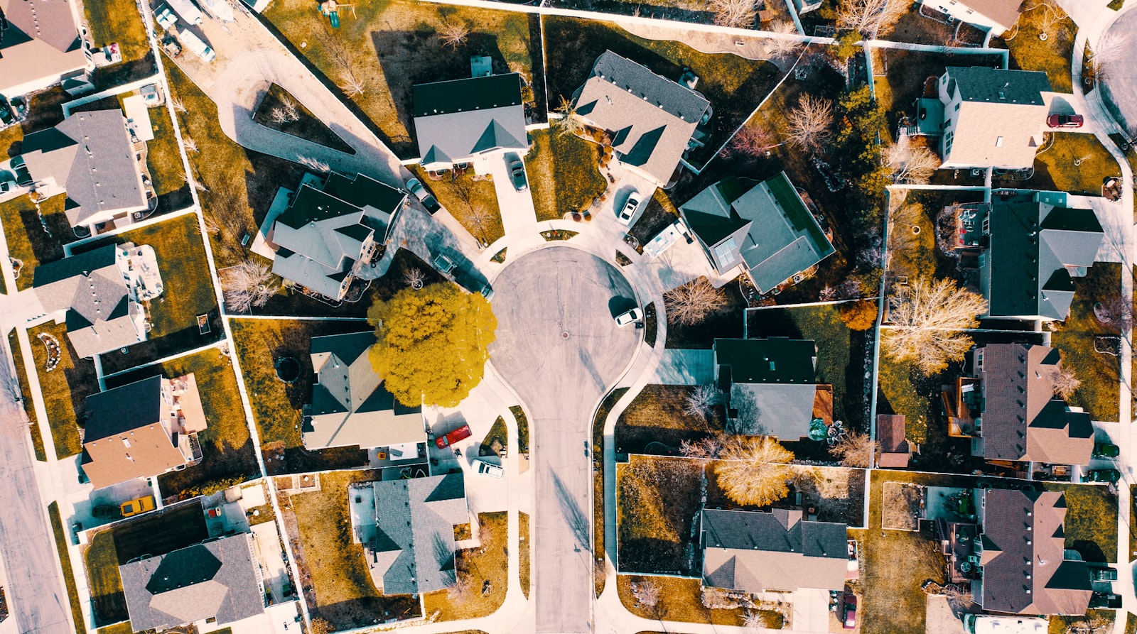 An aerial view of a suburban cul-de-sac with houses, driveways and shared roads