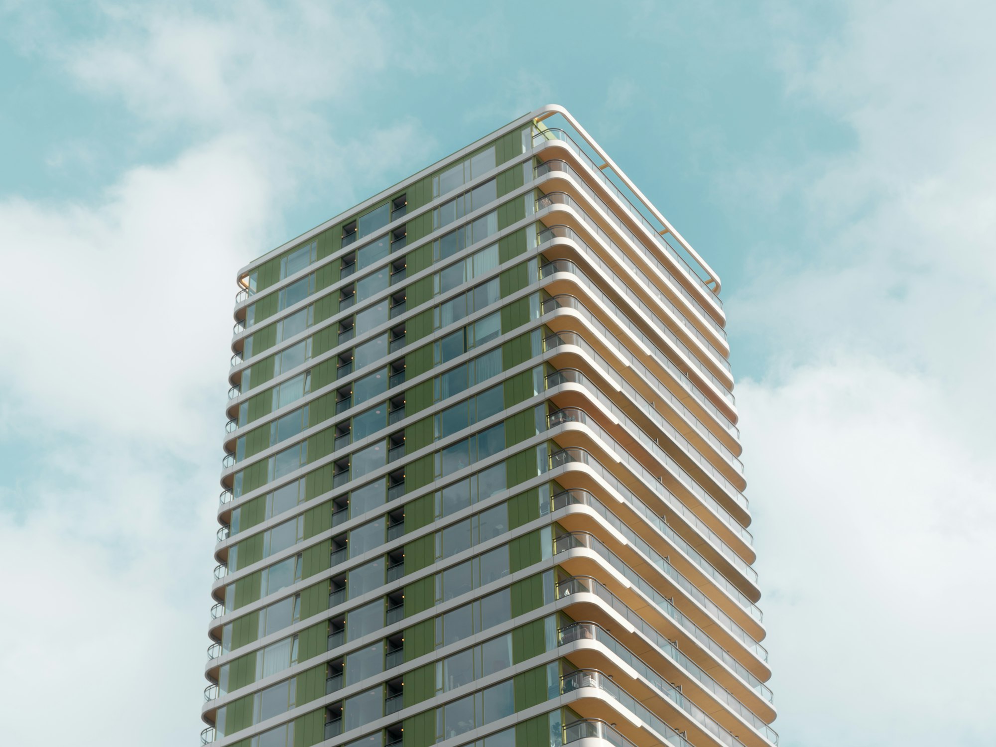 Modern glass condo tower exterior against a blue sky